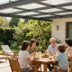 Moderne Terrassenüberdachung bietet perfekten Schatten für ein entspanntes Familienessen im Garten.